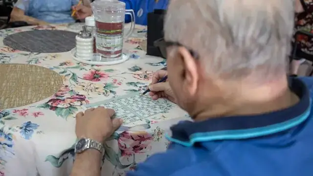 Seniors playing bingo with daubers at a table