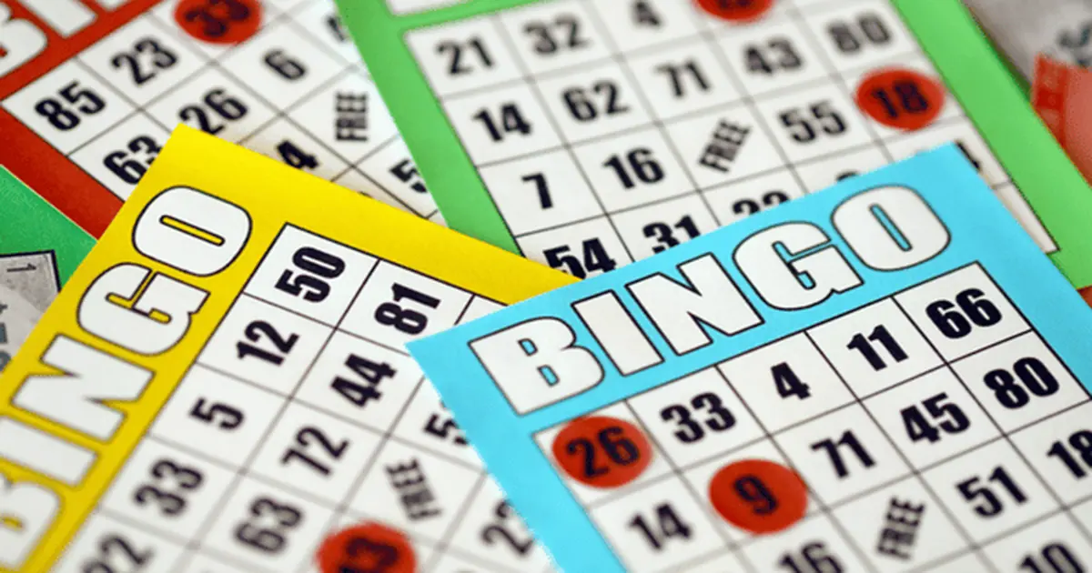 Group of players marking bingo cards with colorful bingo daubers